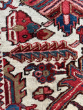 Close up of antique Persian Heriz carpet with oversized room-scale proportions and graphic design.