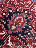 Close up of oversized 1920s Heriz rug with powerful geometric art and durable construction.