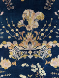 Detailed floral sprays across a midnight blue ground in an antique rug.