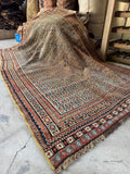 View of antique rug with visible age and soft lived in character draped to highlight floppy handle.