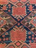 Nomadic Persian rug featuring stacked diamond pattern and rich indigo and rust tones.