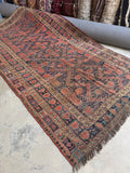 Antique Persian tribal rug handwoven with vegetable dyed wool showing natural color variation.