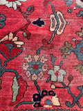 Antique red Persian rug accented with multi-colored floral sprays and soft pastel highlights.