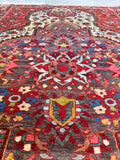 Curvilinear floral medallion rug woven with natural vegetable dyes in multi colors.