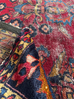 Close-up of a colorful pattern with worn areas on rug.