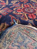 Navy blue antique Persian rug with clover style medallion and vase design.