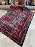 Diagonal view of Lilihan rug with a low pile wool surface and visible age-old wear.