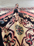 Persian rug featuring rose pink and warm ivory with a bold medallion design.