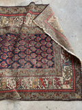 Solid worn Persian runner showing scattered age-related wear.