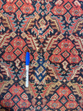 Antique Persian rug with scattered patches blending into the busy design.