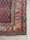 Long Persian hallway runner with an intricate tribal design.