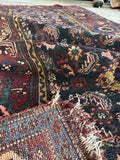 Underside view of authentic Persian Malayer rug with moody colors, tribal energy, and worn in charm.