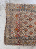 Vintage Persian rug with low pile texture, warm wheat tones, and orange leaf pattern detail.