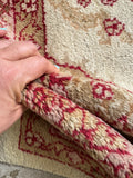Vintage Turkish tribal rug showing berry red, pink mauve, tan, and ivory color palette.
