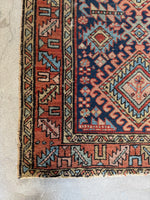 Corner view of Antique Persian Gharajeh rug, handwoven in Northwest Persia with vegetable-dyed wool, featuring bold tribal motifs and low pile.