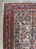 Low pile Persian rug showing age and natural wear.