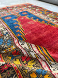 Saturated natural dye area rug with blue and red prayer arch design.