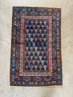 Caucasian rug featuring bold tribal motifs in alternating colors.