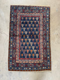 Caucasian rug featuring bold tribal motifs in alternating colors.