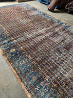 Vintage Persian rug with coral field and soft indigo border featuring botanical patterns