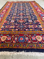Navy field Persian scatter rug with bold red and cardamom border.