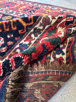 Close-up of a tribal rug with vibrant colors and the underside.