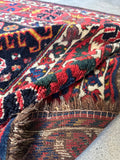 Close-up of a tribal rug with vibrant colors and the underside.