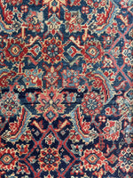Close up view of early 20th century Persian rug with repeating fish design.