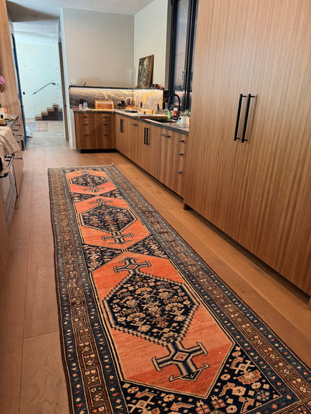 Antique Persian Malayer runner with coral ground and triple diamond medallions.