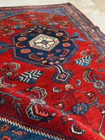 Overview of small Persian Malayer rug with a bold red ground.
