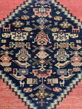 Close-up of geometric medallion detailing on early 1900s Malayer rug.
