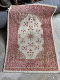 Hand-knotted Turkish area rug showing delicate floral artwork and subtle fish design motifs.