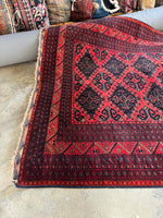 One end view of tribal motifs on a vintage Afghan rug.
