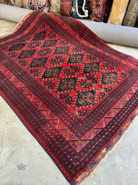 Antique mid-century Afghani rug with bold red ground and tribal medallion lattice design.