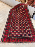 Vintage Baluchi tribal area rug 3x5 overhead full shot displaying a vibrant red field with a geometric repeating lattice pattern.