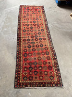 Persian runner with orange-red to peach abrash field and floral design.