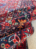 Large antique Persian gallery rug. Vintage Heriz carpet with bold geometric design, vibrant natural colors, and healthy shorter wool pile in very good condition.