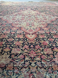 Close-up of fine weave and botanical motifs on antique Ferahan rug.