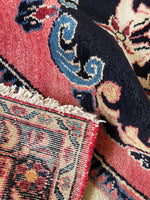Underside view of luxurious vintage Persian rug with rose, blue, and ivory color story.