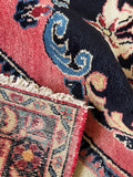 Underside view of luxurious vintage Persian rug with rose, blue, and ivory color story.