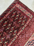 Antique Yomut storage bag face woven in fine wool, laid flat to highlight its plush texture and vibrant accents.