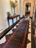 Deep navy Persian runner styled in a long and narrow hallway setting.