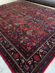 Close-up of charcoal border with ornate detailing on Persian rug.