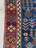 Handwoven antique Caucasian rug with low pile and secured sides.