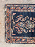 Long, narrow antique Persian rug end view.