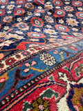 Persian rug closeup along the red and blue outer border.
