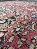 Ornate floral rug close-up detailing fine wool knotting and vegetable dyed wool.