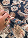 Faded antique Persian area rug showing plush wool texture.