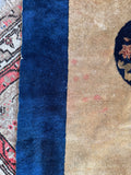 Wheat beige Chinese Art Deco accent rug measuring 3 feet by 6 feet with a dark navy blue border.