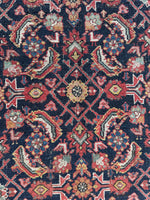 Vintage Persian rug showing Mahi design with age and character in rich colors.